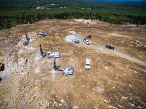 Saunders drilling and blasting crew with drill rigs drilling and the blast crew loading a blast on a commercial site